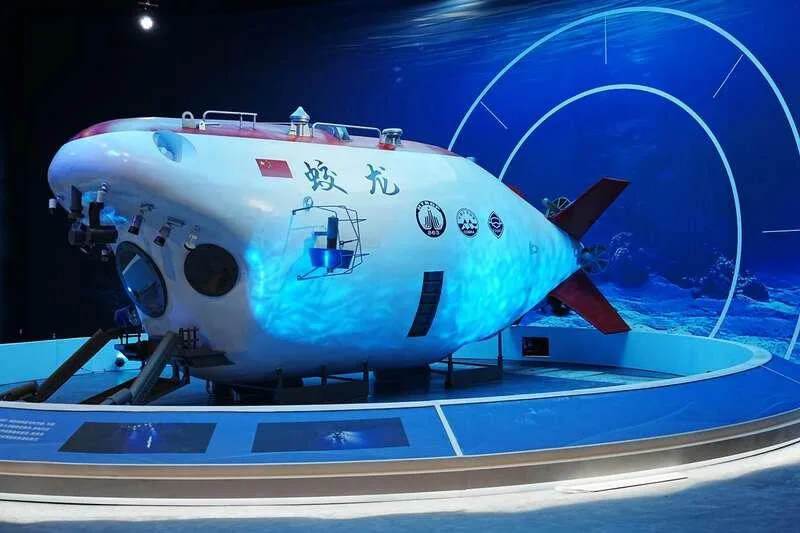 展厅中展出的「蛟龙」号载人深潜器模型,背景是深海主题灯光。