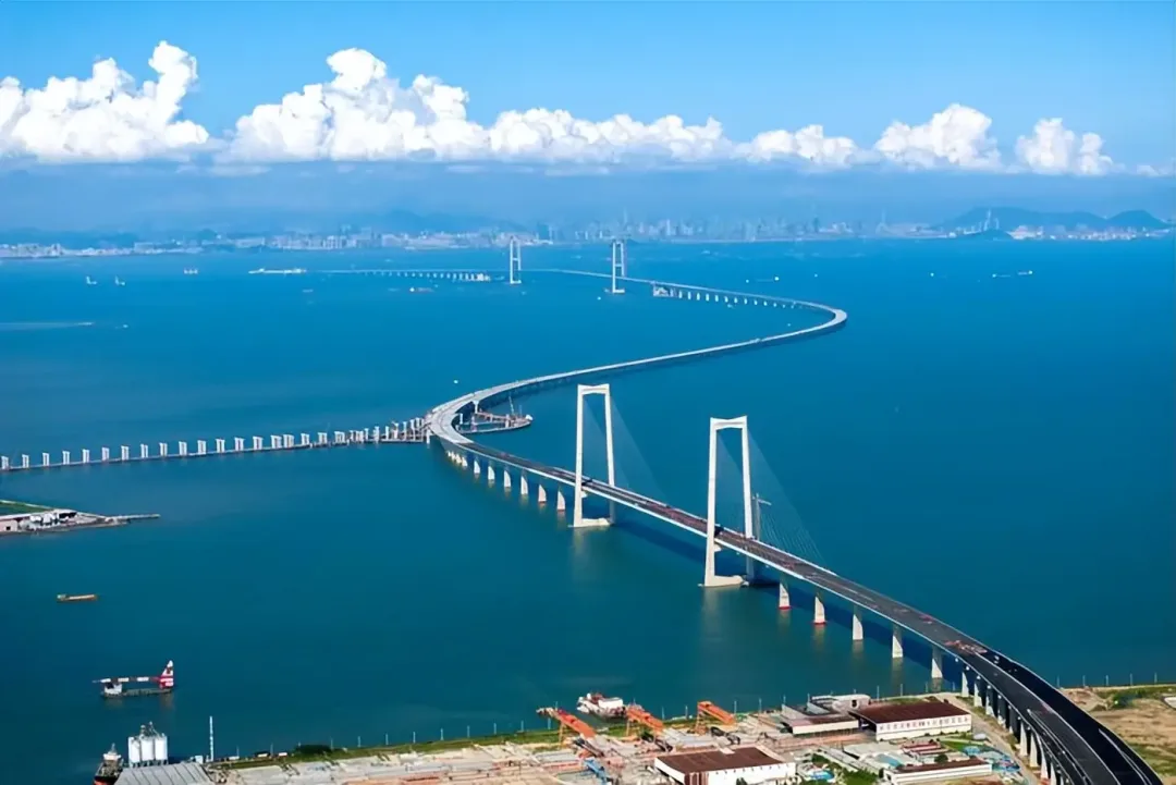 航拍深中通道:跨海大桥呈 S 形延伸,串起人工岛与远处城市。