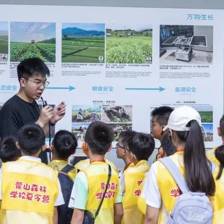 讲解员在「万物生长」展板前,向穿黄色营服的孩子们讲解生态、粮食与能源安全。