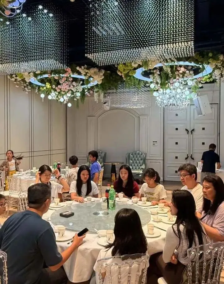 Children and parents seated at round banquet tables under floral chandeliers at the opening dinner