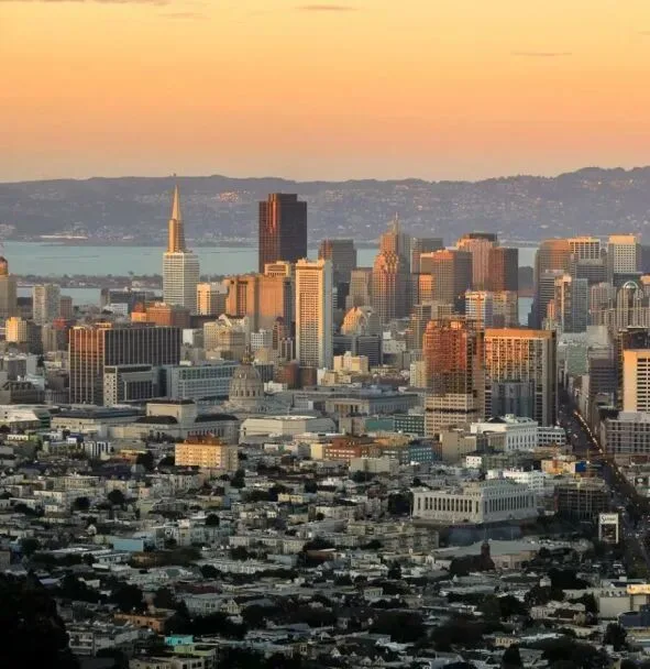 San Francisco's downtown skyline at sunset, the Transamerica Pyramid rising above the bay.