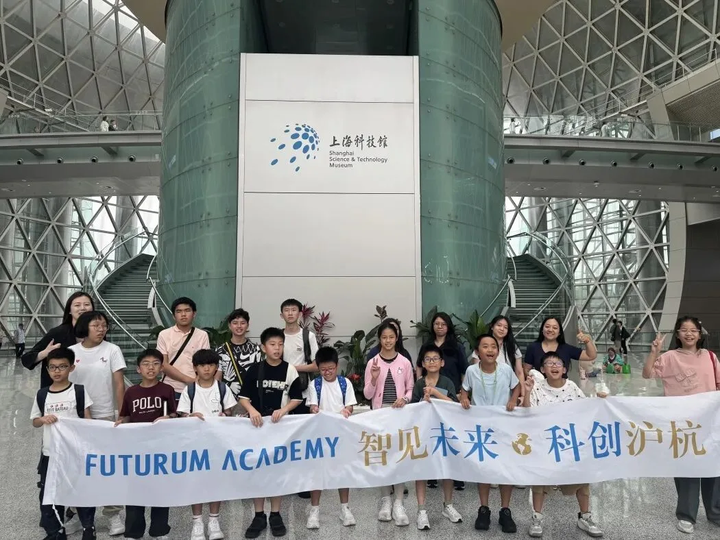 The group holds its banner in the atrium of the Shanghai Science and Technology Museum