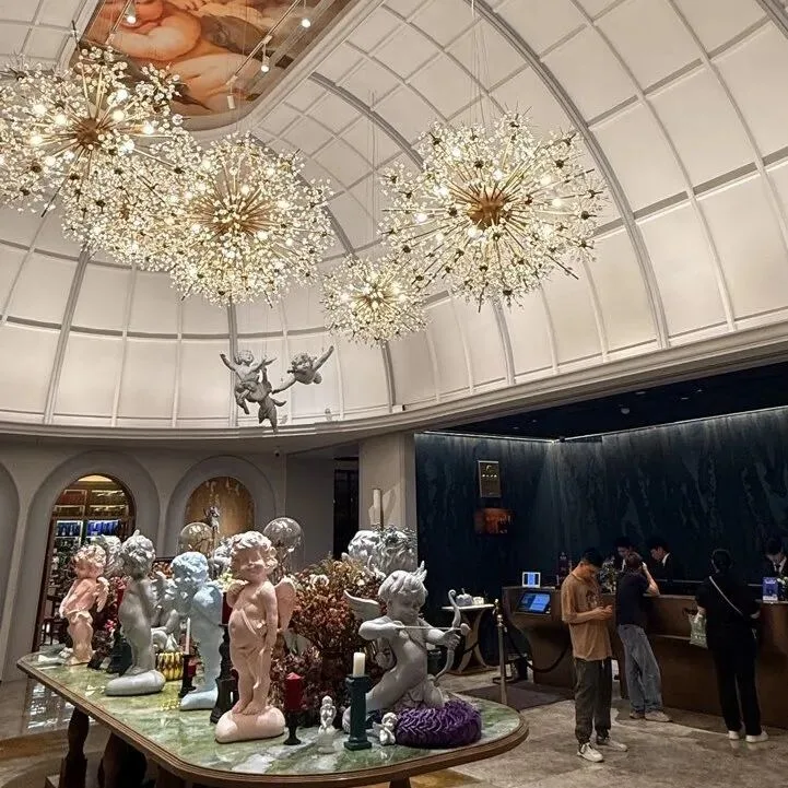 A domed hotel lobby with starburst chandeliers, cherub statues and the reception desk