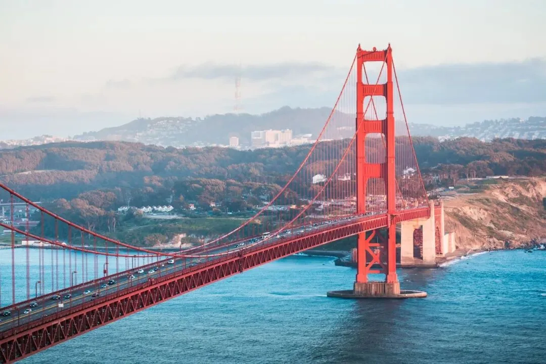 The Golden Gate Bridge stretching across the bay with traffic crossing and hills beyond.