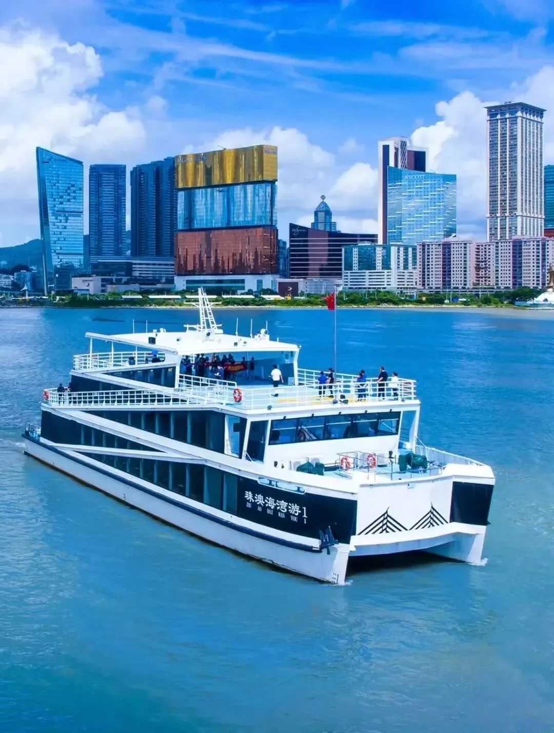 The Zhuhai-Macau bay cruise catamaran on turquoise water with Macau's casino towers behind.
