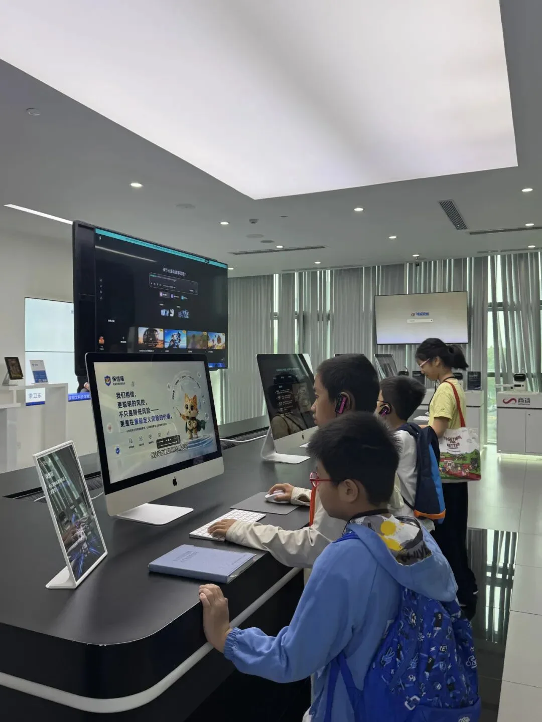 Children try AI demonstrations at desktop workstations in a bright showroom