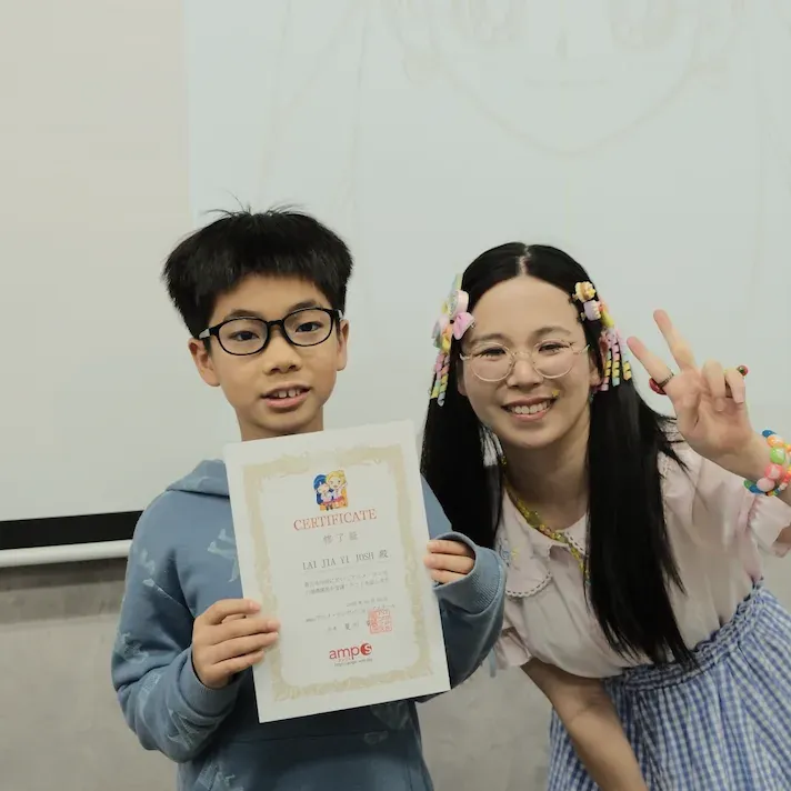 A boy holding his amps certificate of completion beside a smiling instructor
