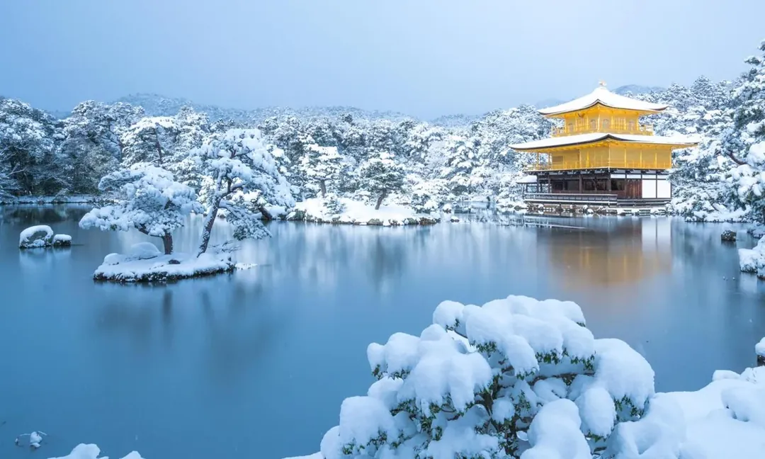 Kinkaku-ji, the Golden Pavilion in Kyoto, under snow beside its mirror pond